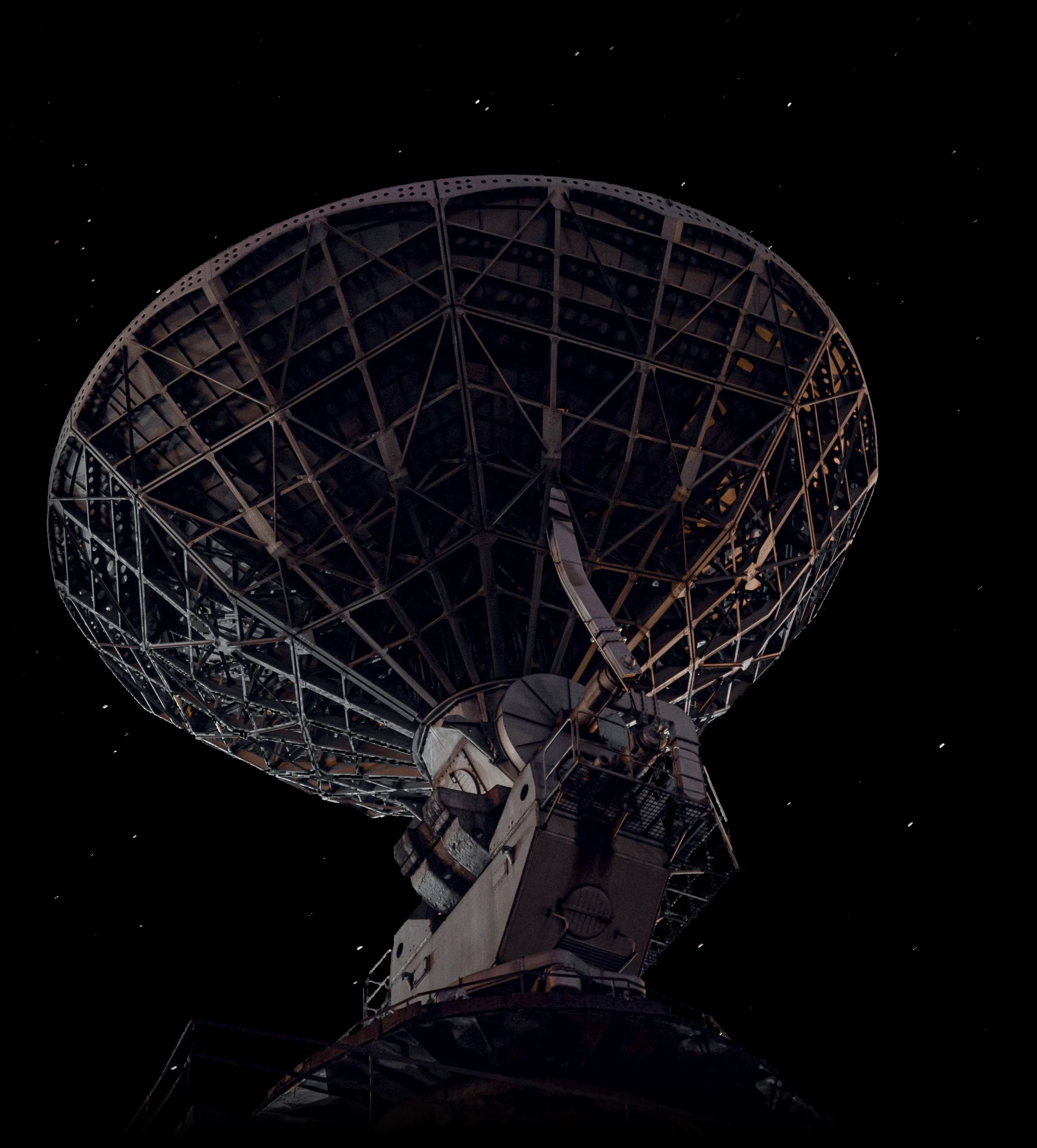 A large radio telescope dish pointed at a starry night sky